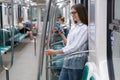 Passenger young woman using mobile smart phone chatting in social networks in subway train at metro Royalty Free Stock Photo