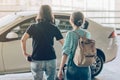 Passengers with big roller luggage stand to wait for the car to pick up