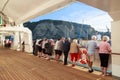 Passengers on a cruise liner, looking out at port