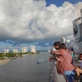 Passengers on  a cruise ship leaving Port Everglades, in Ft. Lauderdale, Florida look out over the ocean channel  with a luxury Royalty Free Stock Photo