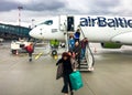 Passengers get off the Airbaltic plane arrived in Riga on a rainy day.