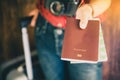 Passengers hold passports and travel luggage tickets to show to