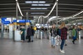 Passengers inside large modern railway terminal concourse