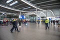 Passengers inside large modern railway terminal concourse