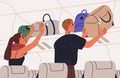 Passengers placing hand baggage, personal carry-on luggage on overhead bin, shelf in air plane. People putting bags Royalty Free Stock Photo