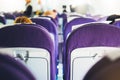 Passengers are sitting in the blue armchairs of the aircraft during the flight, the view from the back of tourists flying