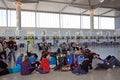 Passengers sitting on the floor in the check in hall at Malaga airport, Spain.