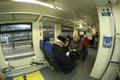 Passengers sitting on seats in the wagon of commuter train, waiting for departure, suitcases and bags put in the section for Royalty Free Stock Photo