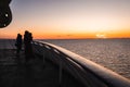 Passengers at the sun deck at sunset watching the sea on board Silja Europa