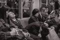 Passengers tired of work sleeping on a late night train in Hiroshima Japan