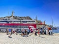 Passengers and travellers arrive and wait to embark to the Flying dolphin at the port of Hydra, Greece