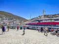 Passengers and travellers arrive and wait to embark to the Flying dolphin at the port of Hydra, Greece