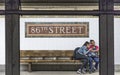 Passengers wait at a bench at 86th street for the next metro Royalty Free Stock Photo