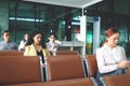 Passengers wait for flight, travelers siting at departure terminal airport, using mobile phone for checking information, holiday Royalty Free Stock Photo