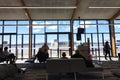 Passengers waiting in airport departure lounge. Couple, checking.