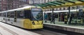 Passengers waiting for ariving tram on the platform at St Peters Square Station. Public Transport Vehicle. People in shot