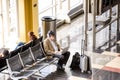 Passengers waiting in front of a bright interior airport window