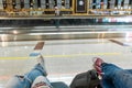 Passengers are waiting for their flight in the airport waiting area. First-person view, girl in ripped jeans Royalty Free Stock Photo