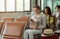 Passengers waiting for their flight in airport terminal and using mobile phone Royalty Free Stock Photo