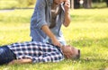 Passerby calling ambulance while checking pulse of unconscious man outdoors Royalty Free Stock Photo