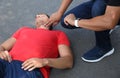 Passerby checking pulse of unconscious young man