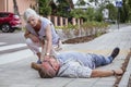 Passerby checks the vital functions of the person who fainted on the street