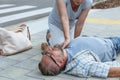 Passerby checks the vital functions of the person who fainted on the street