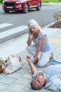 Passerby kneels beside the person who fainted on the street and calls an ambulance