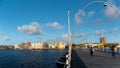 Passerby on the Queen Emma Bridge in the light of early sunset on Curacao.