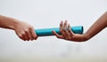 Passing the baton to future generations. two athletes passing a baton during a relay race. Royalty Free Stock Photo