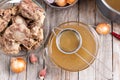 Passing the bone broth through a sieve. Concentrated Bone Broth in a bowl on the table