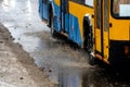 Passing cars in a large puddle during rain and sleet. Large splashes from under the wheels of the car. Mud, snow and puddles on a