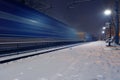 Passing freight train in blurred motion at train station on a winter night Royalty Free Stock Photo