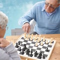 Passing the time with an engrossing game of chess. An elderly couple playing a game of chess.