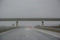 Passing under a bridge on an highway, rainy days, car driving through water from the storm, bad weather Royalty Free Stock Photo