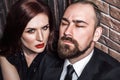 Passion concept, closeup. Bearded man closed eyes, redhead sensual woman with red lips and handsome makeup, looking at camera