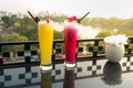 Passion fresh fruit juice with ice on outdoor table in cafe and bar. Pineapple and red dragon fruit. Urban lake on background Royalty Free Stock Photo