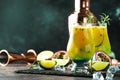 Passion fruit cocktail with rosemary and ice cubes in glass, bar tools, copy space Royalty Free Stock Photo