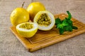 Passion fruit. Passion fruit cut in front of two fruits with mint leaves on the wooden cutting board in jute fabric Royalty Free Stock Photo