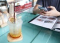 Passion fruit juice with soda on the table and background of a man using mobile smart phone in restaurant Royalty Free Stock Photo