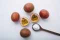 Passion fruit with salt in wooden spoon on wooden white background.