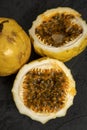 Passion fruit, whole and sliced, on black stone table Royalty Free Stock Photo