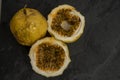 Passion fruit, whole and sliced, on black stone table Royalty Free Stock Photo