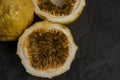 Passion fruit, whole and sliced, on black stone table Royalty Free Stock Photo