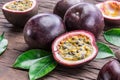 Passion fruits and its cross section with pulpy juice filled with seeds. Wooden background