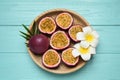 Passion fruits maracuyas, palm leaf and flowers on light blue wooden table, top view Royalty Free Stock Photo