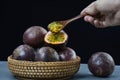 passion fruits within a wooden basket and a wooden spoon over them Royalty Free Stock Photo