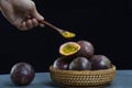 passion fruits within a wooden basket and a wooden spoon over them Royalty Free Stock Photo