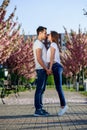 Passion and love concept. Man and woman kissing in blooming garden on spring day. Couple hugs near sakura trees. Couple Royalty Free Stock Photo