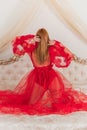 Sensual red hair woman in a red lace boudoir dress on a bed Royalty Free Stock Photo